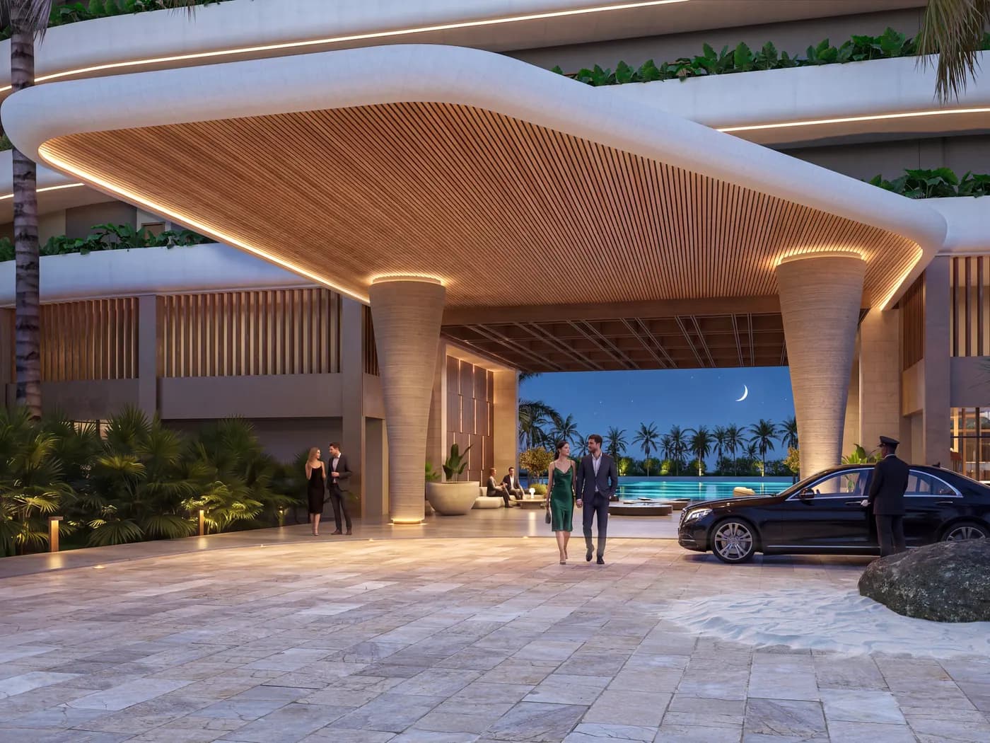 The Bonita Beach entrance at night: wood slat canopy over travertine columns, the pool lit beyond, a crescent moon above.